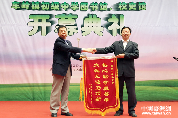 车岭镇初级中学校长张均向顶新公益基金会理事王兴华授旗